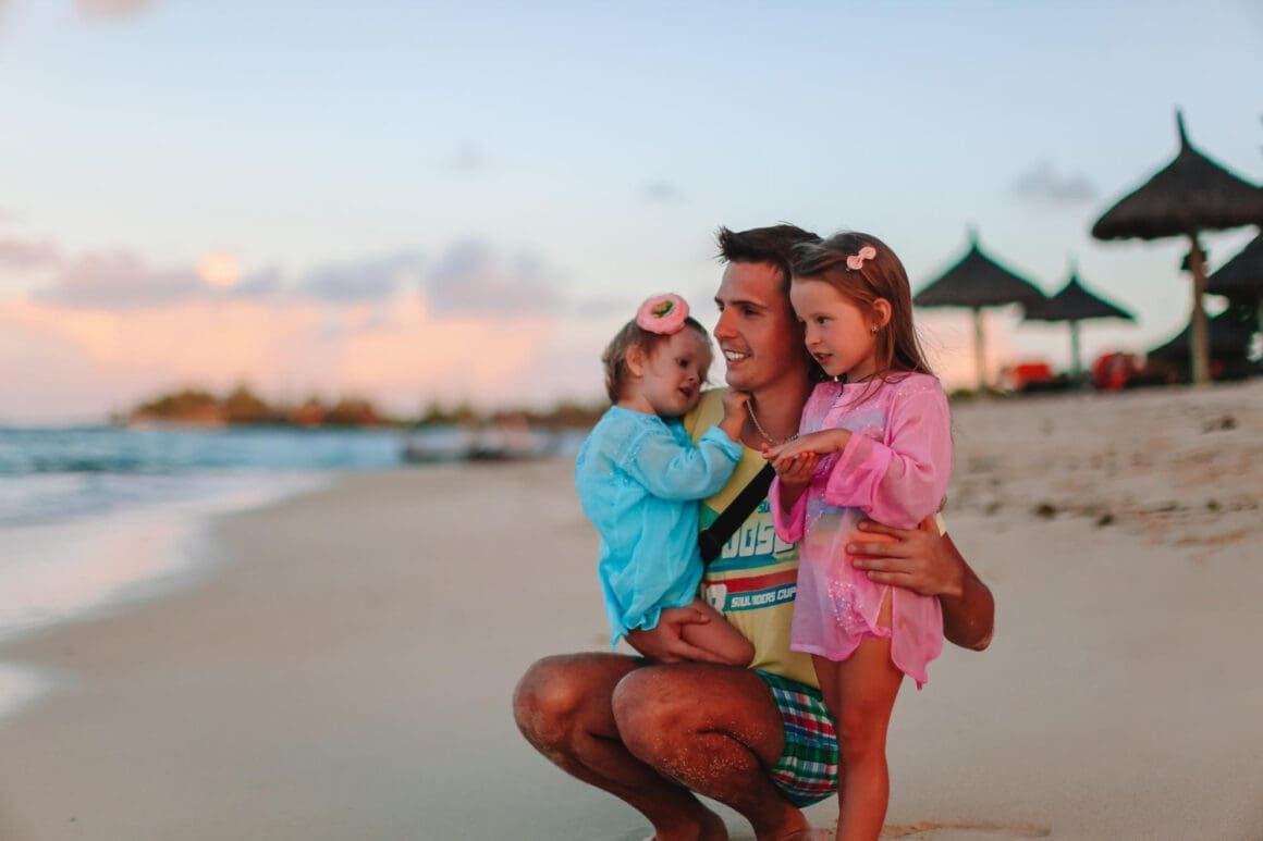 A young dad enjoying a vacation with his two young daughters
