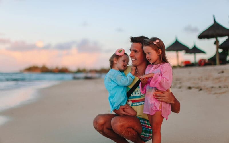 A young dad enjoying a vacation with his two young daughters