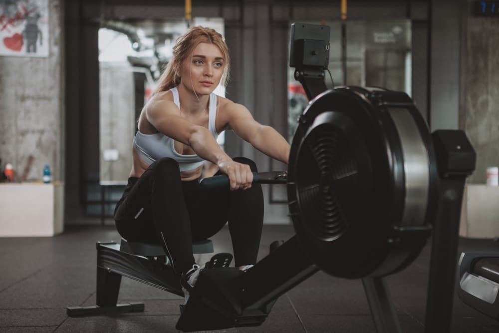 Beautiful young fitness enthusiast exercising on an Echelon Row-S