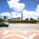 Classic car driving by a monument in Cuba