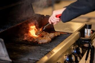 Close-up of a hand preparing barbecue