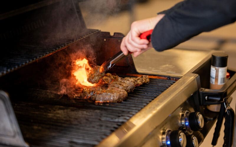 Close-up of a hand preparing barbecue