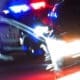 Close-up of a police car pursuit on a brightly lit street at night