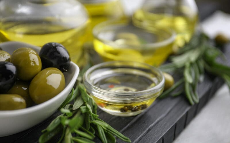 Composition with healthy olives and oil on kitchen table