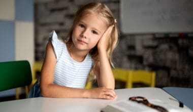 Front-facing view of a young girl seated at a table