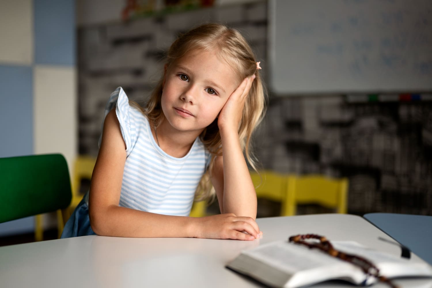 Front-facing view of a young girl seated at a table