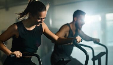 Happy couple cycling as part of their cross-training at a fitness center