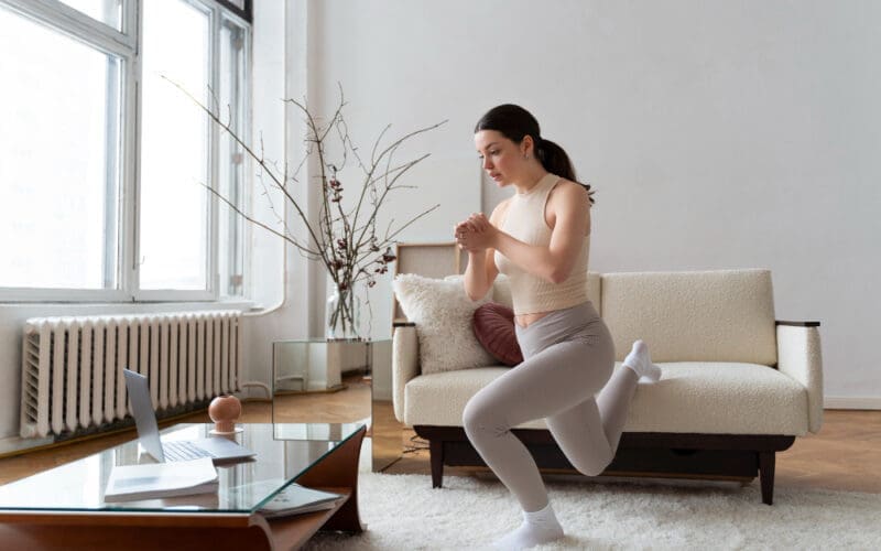 Woman exercising following guidance from an online fitness instructor