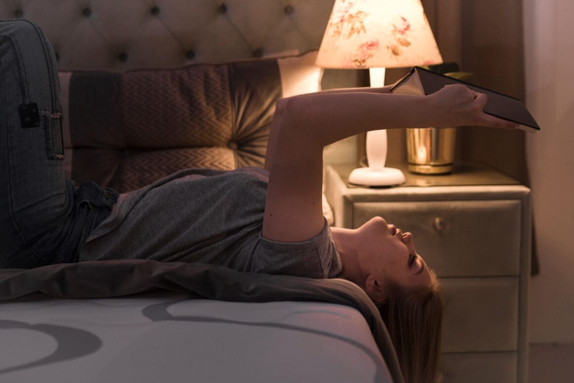 Young, attractive woman lounging on her back in bed