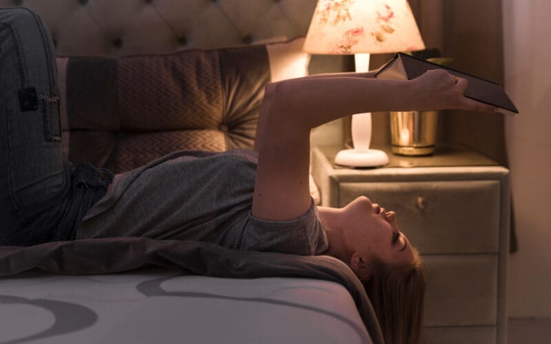 Young, attractive woman lounging on her back in bed