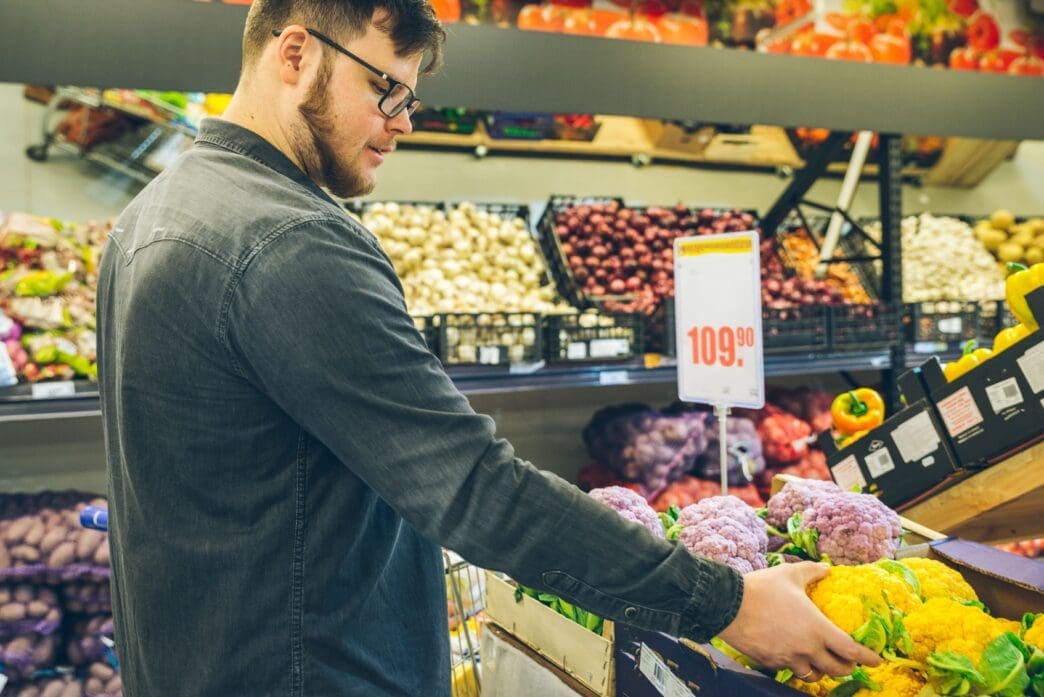 man seek vegetables in supermarket