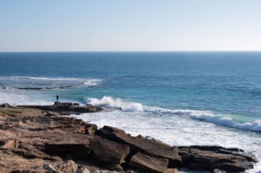 A man gazes thoughtfully at the Atlantic Ocean, feeling a sense of solitude