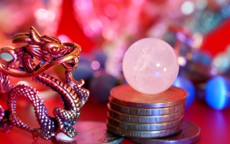 A Chinese dragon statuette with coins and a quartz crystal ball. Reiki, fortune telling, esotericism and horoscope