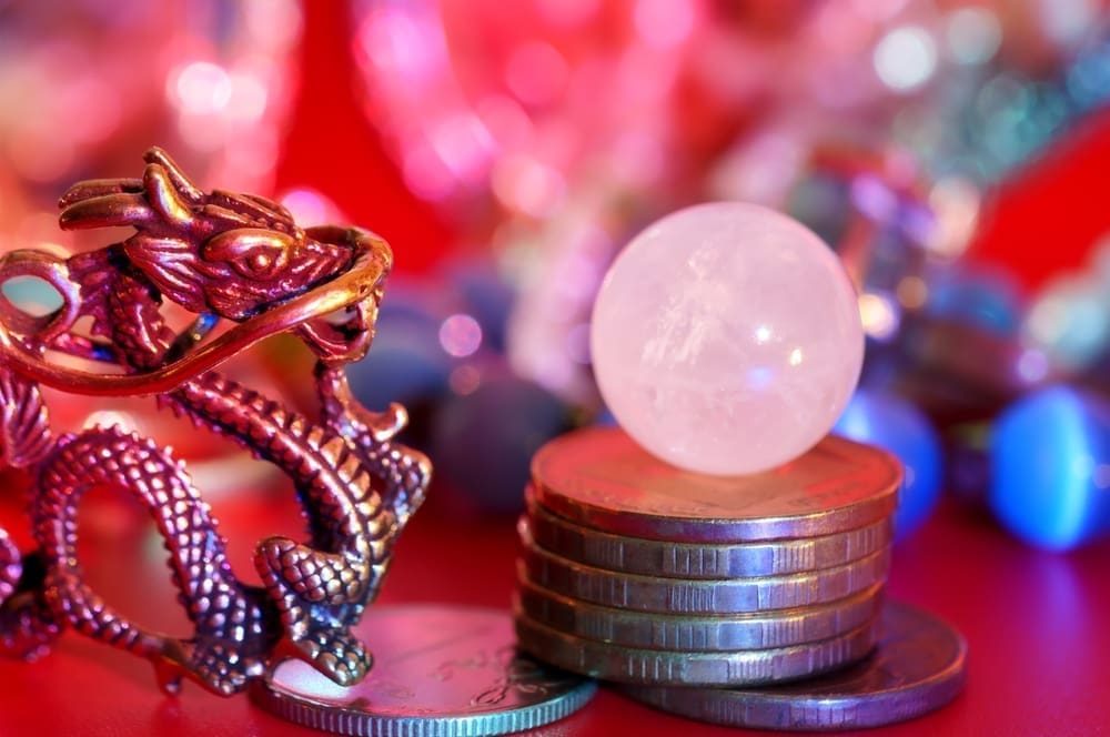A Chinese dragon statuette with coins and a quartz crystal ball. Reiki, fortune telling, esotericism and horoscope