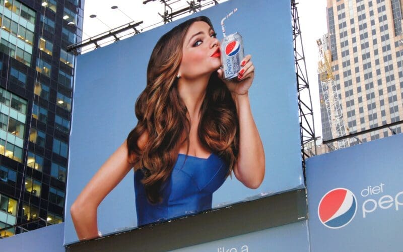 A billboard showing a young attractive woman on a Pepsi advertisement