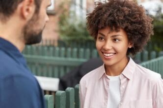 A cheerful young girl is gently listening to her friend as they talk
