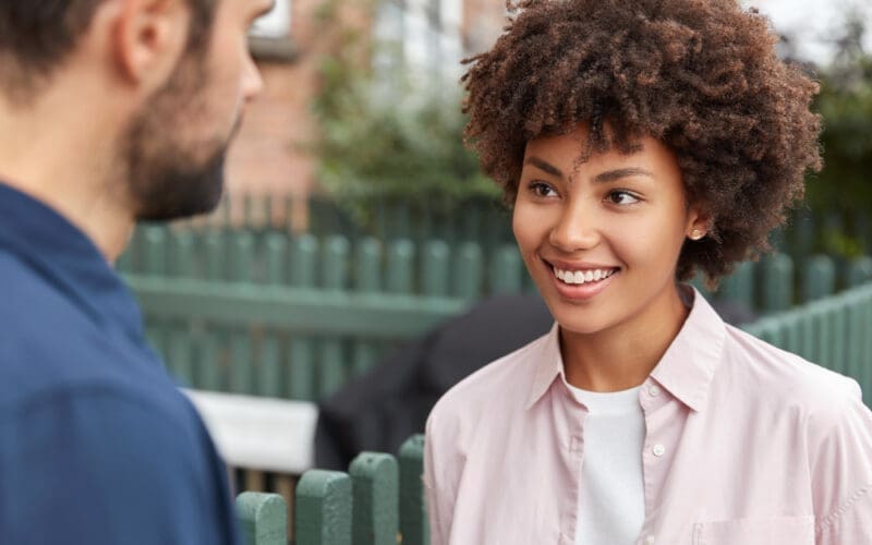 A cheerful young girl is gently listening to her friend as they talk