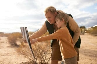 A medium shot of a child and an adult examining a sign in a foreign country.