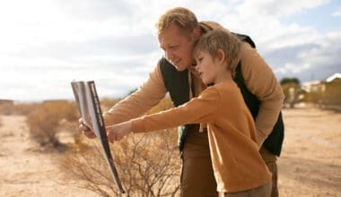 A medium shot of a child and an adult examining a sign in a foreign country.