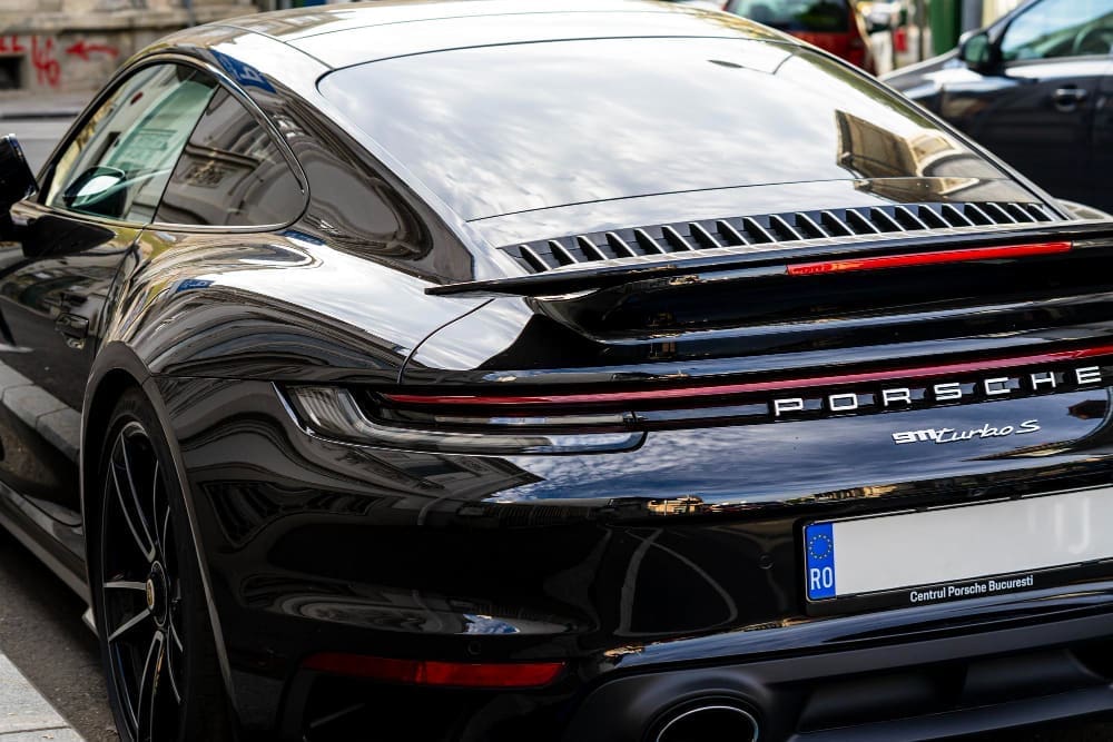A rear view of a Porsche 911 Turbo S, showcasing the emblem of the luxury car brand