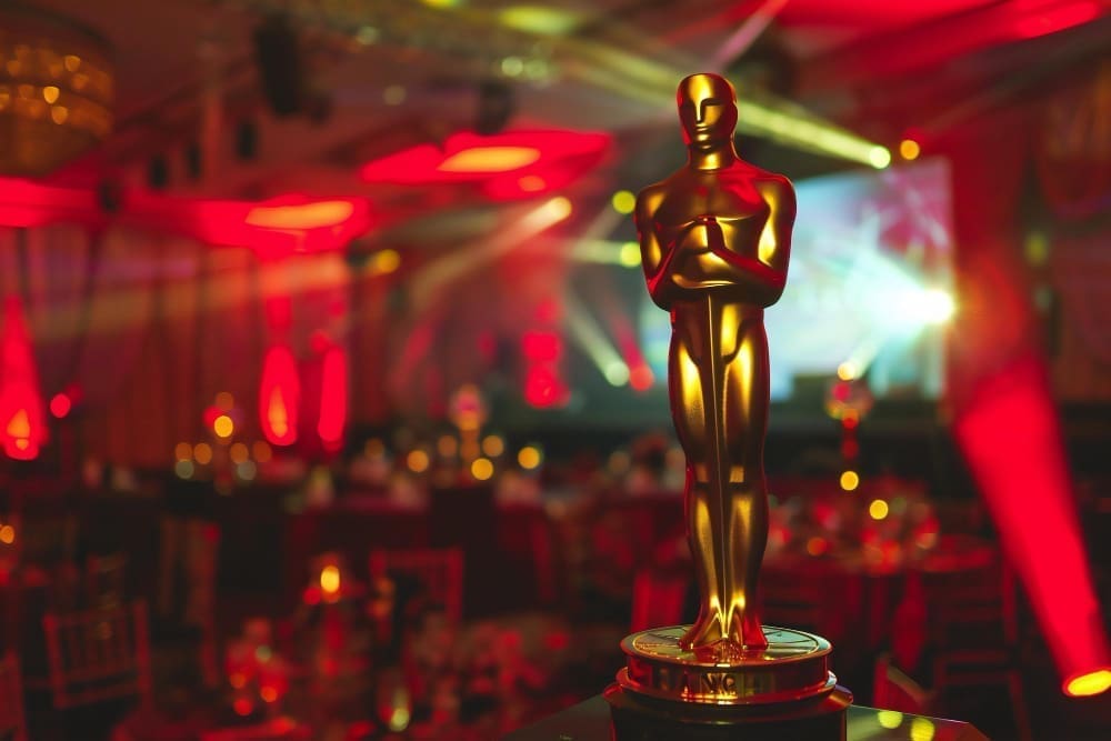 A red light shines behind an Oscar statue in a room illuminated by a red light event