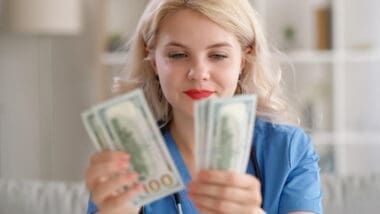 A thrilled woman counting her dollar bills, symbolizing financial success