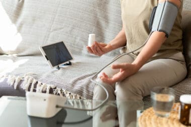 A woman taking a close-up measurement of her blood pressure at home