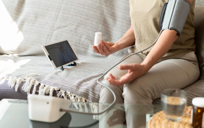 A woman taking a close-up measurement of her blood pressure at home