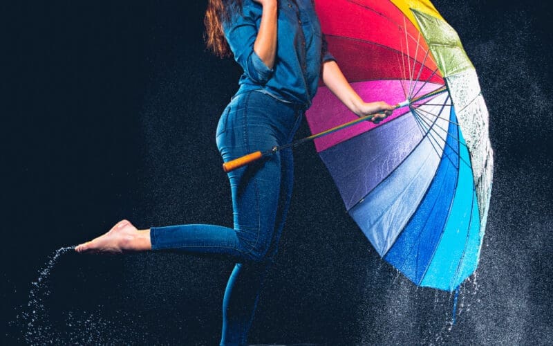 A young, beautiful, and confident woman holding an umbrella