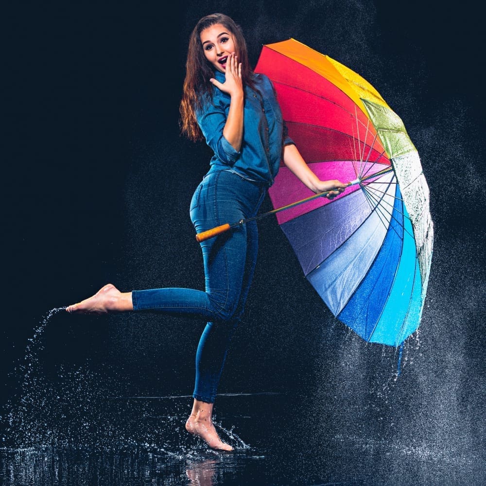 A young, beautiful, and confident woman holding an umbrella
