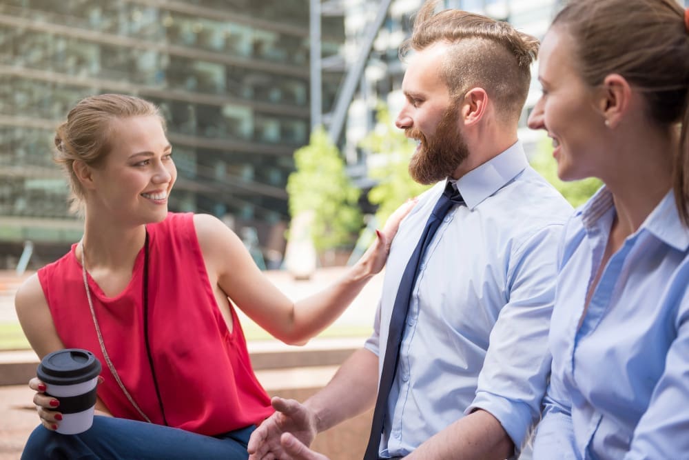 A young, beautiful woman tells her colleague, You are the best in our team