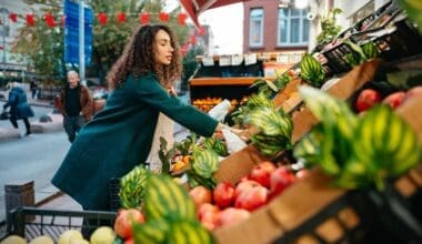 A young woman selecting items to purchase from a local farmers market stall in London