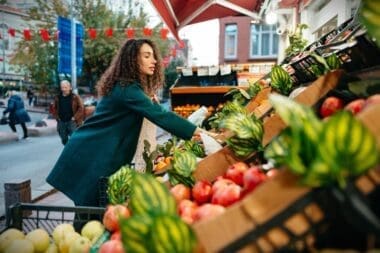 A young woman selecting items to purchase from a local farmers market stall in London
