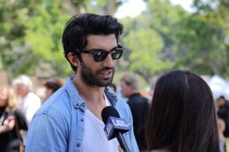 Actor Justin Baldoni talks to a reporter at the “Rocket’s Universe” grand opening, which is the 64th universally accessible playground built by Shane’s Inspiration