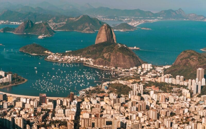 Aerial view of Rio de Janeiro, bathed in sunlight, nestled between the sea and hills in Brazil