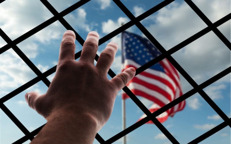 American flag displayed through wire mesh, symbolizing the concept of deportation