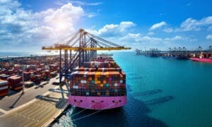 Bird's-eye view of a cargo ship and shipping containers in the harbor