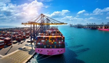 Bird's-eye view of a cargo ship and shipping containers in the harbor