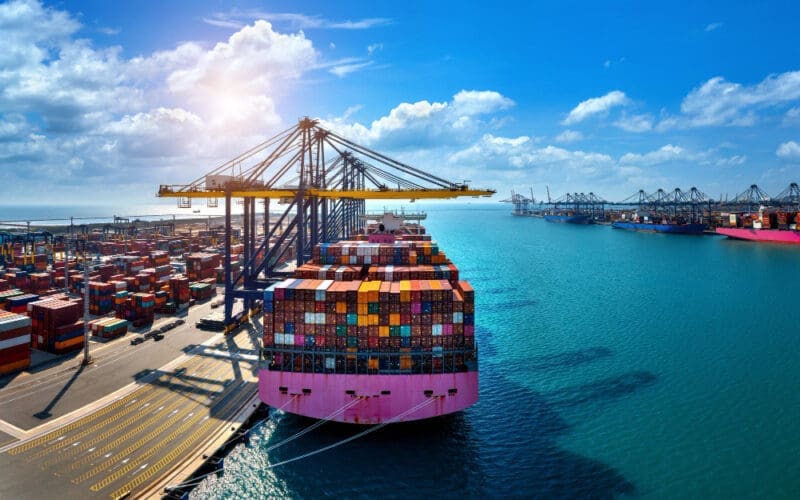 Bird's-eye view of a cargo ship and shipping containers in the harbor