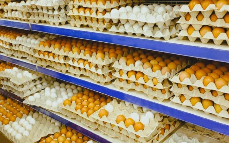 Cardboard trays with chicken eggs on shelves at supermarket