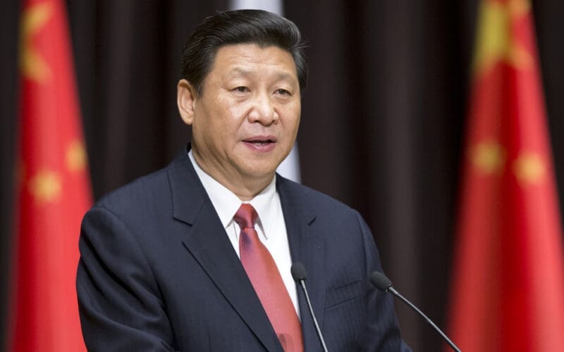 A close-up portrait of Chinese President Xi Jinping speaking at a podium in Moscow.