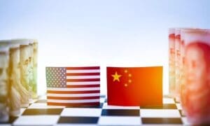 Close-up of a chessboard symbolizing the economic rivalry between the USA and China, featuring flags and currency from both nations