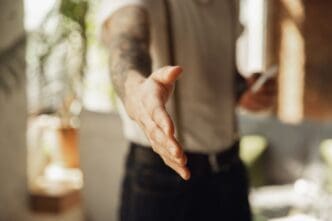 Close-up of a male hand extending in greeting, welcoming someone