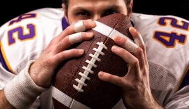 Close-up portrait of an American football player gently kissing the ball