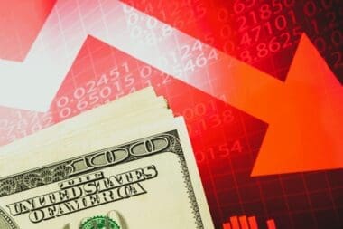 Concept of inflation, economic collapse, and stagnation depicted with the US dollar on a red stock chart featuring downward arrows