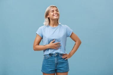 Cute girl likes eat after workout being pleased and stuffed after dinner