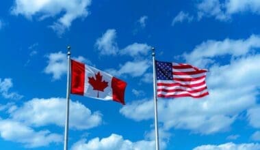 Flags of Canada and the USA against a backdrop of blue sky