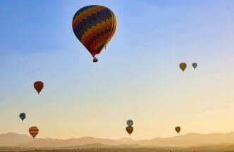 Many hot air balloons flying on the sky at sunrise in Temecula, California USA