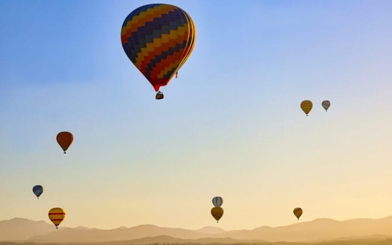 Many hot air balloons flying on the sky at sunrise in Temecula, California USA