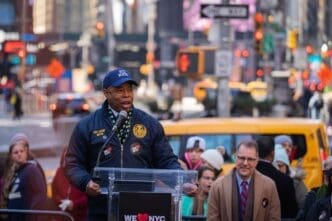 New York City Mayor Eric Adams speaks at a podium during the launch of the We Love NYC campaign